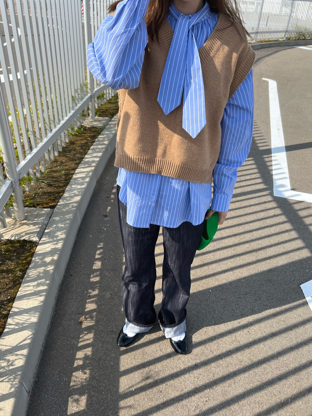 ブルー系のデニムパンツ、ブルー系のシャツ/ブラウス、ブラウン系のベストを着用したレディースの秋コーディネートの3枚目の写真