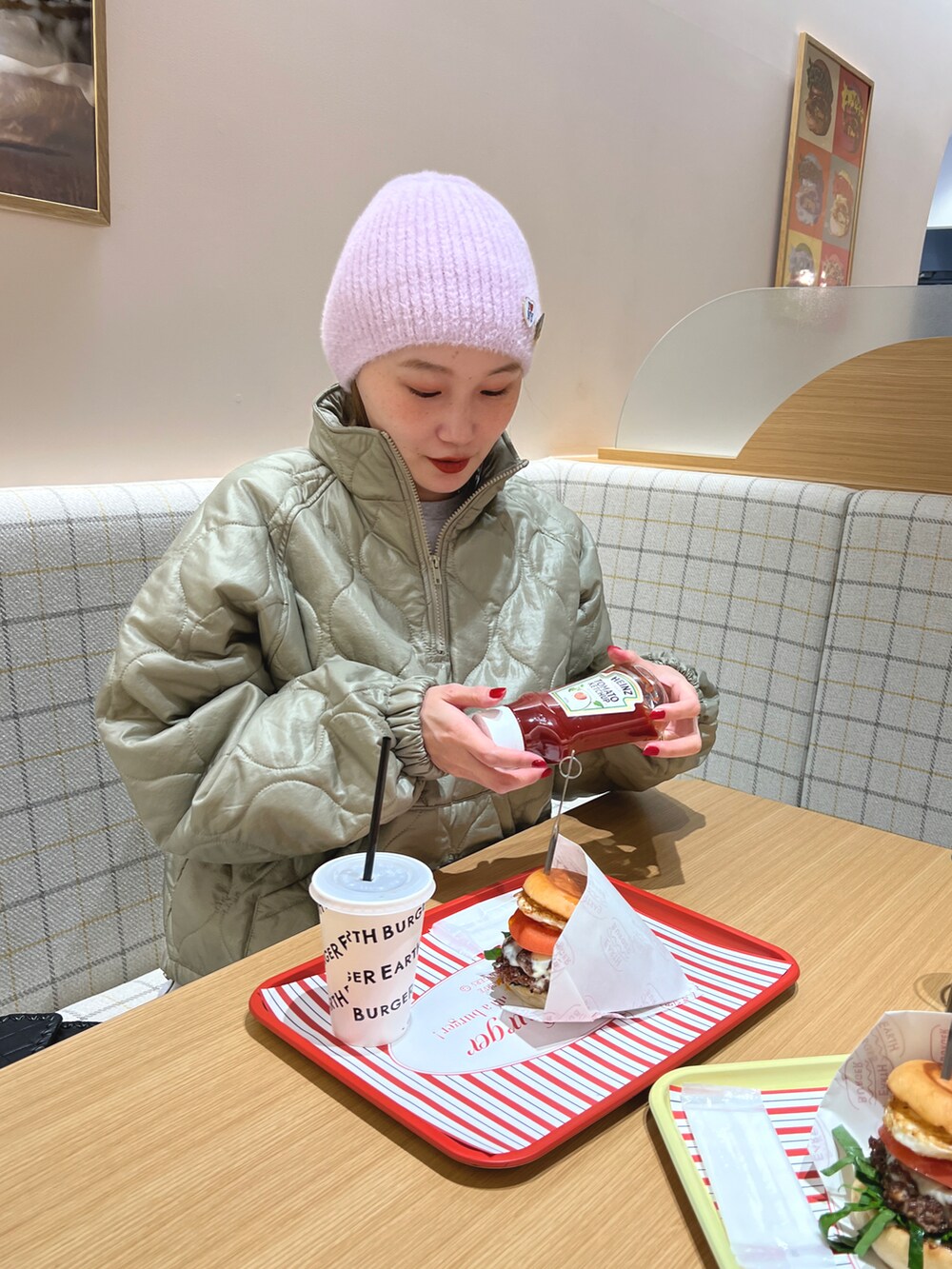 ブルー系のデニムパンツ、グリーン系のジャケット/アウター、ブラウン系のスニーカーを着用したレディースの冬コーディネートの3枚目の写真