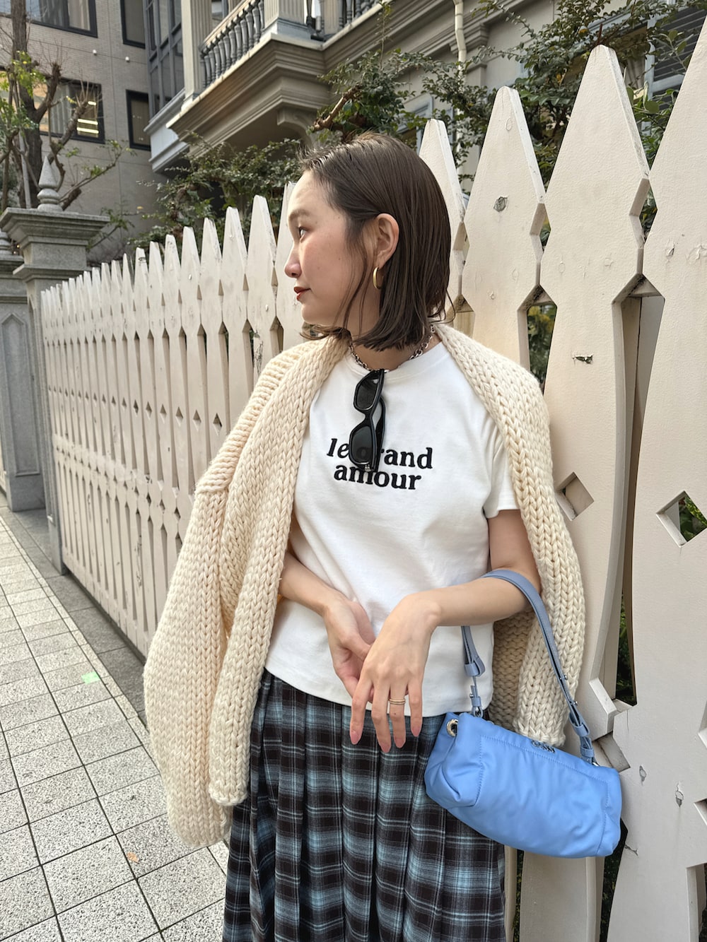 ベージュ系のカーディガン/ボレロ、ブルー系のスカート、ブルー系のハンドバッグを着用したレディースの冬コーディネートの4枚目の写真