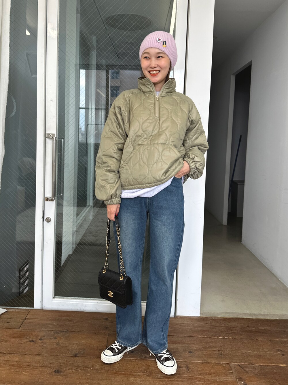 ブルー系のデニムパンツ、グリーン系のジャケット/アウター、ブラウン系のスニーカーを着用したレディースの冬コーディネートの2枚目の写真