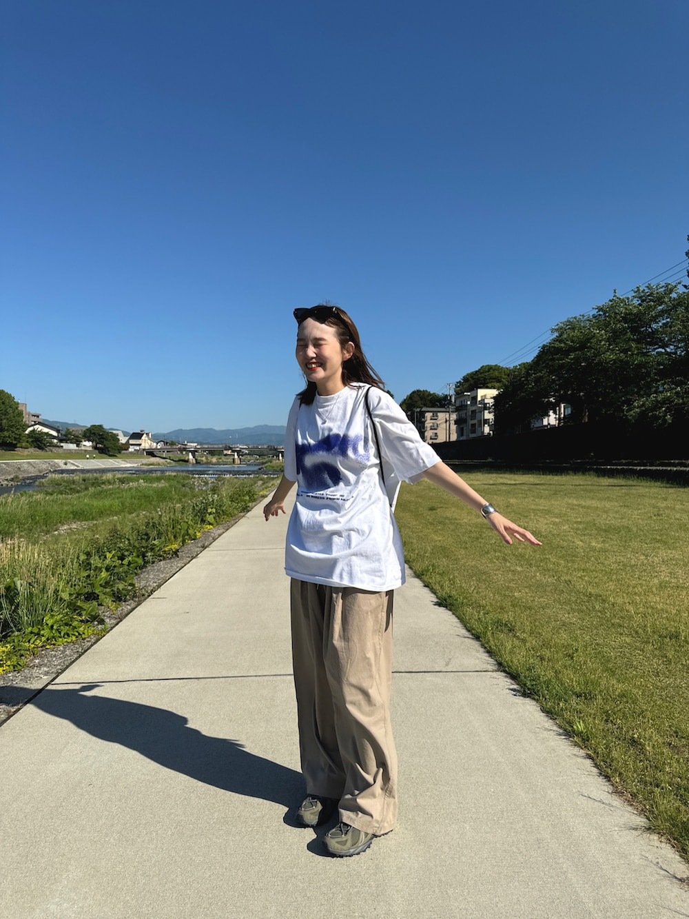 ホワイト系のTシャツ/カットソー、ベージュ系のパンツ、グリーン系のスニーカーを着用したレディースの春コーディネートの4枚目の写真