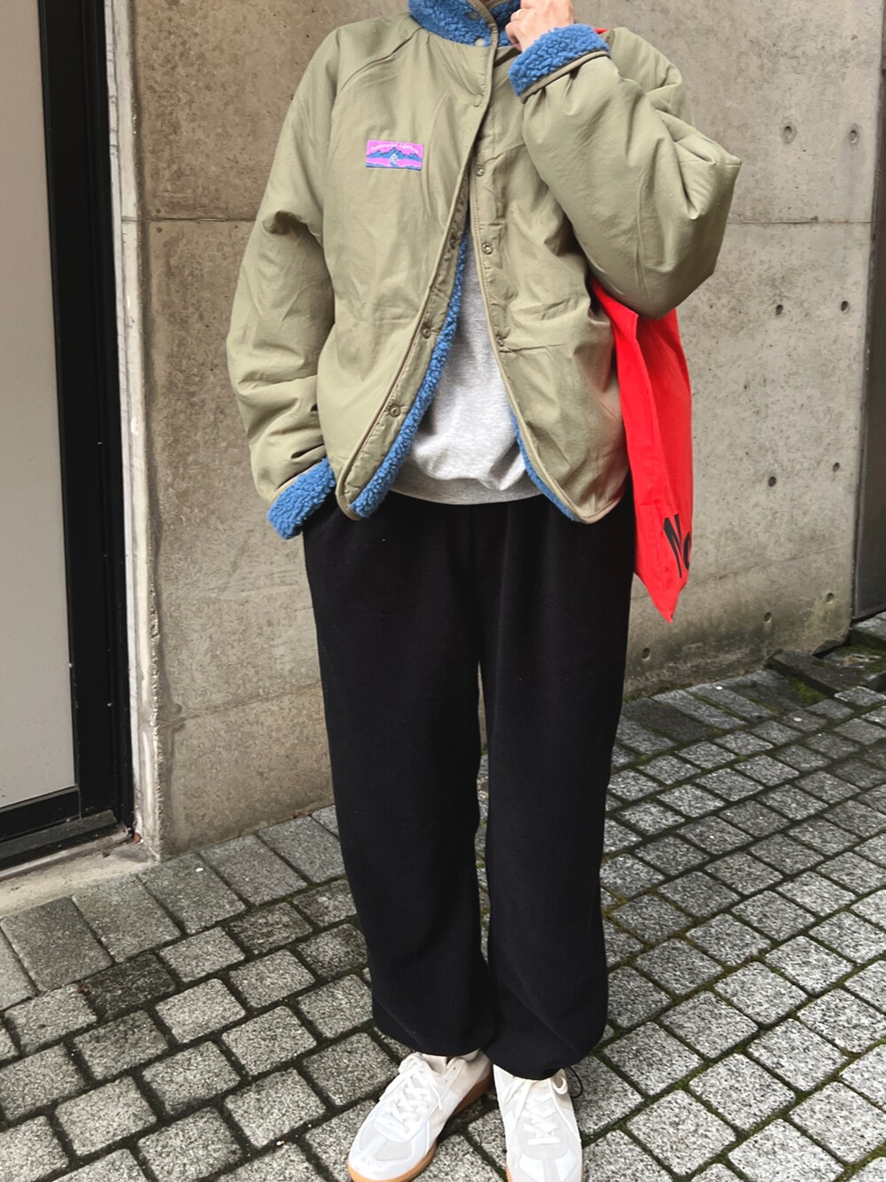 ブラック系のパンツ、ブルー系のジャケット/アウター、ホワイト系のスニーカーを着用したレディースの冬コーディネートの4枚目の写真