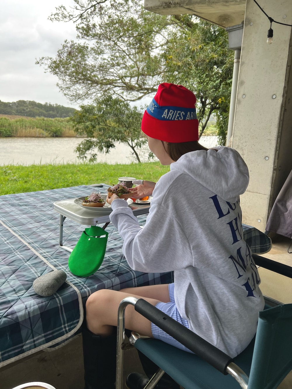 ブルー系のパンツ、グレー系のパーカー、レッド系のニットキャップ/ビーニーを着用したレディースの秋コーディネートの3枚目の写真