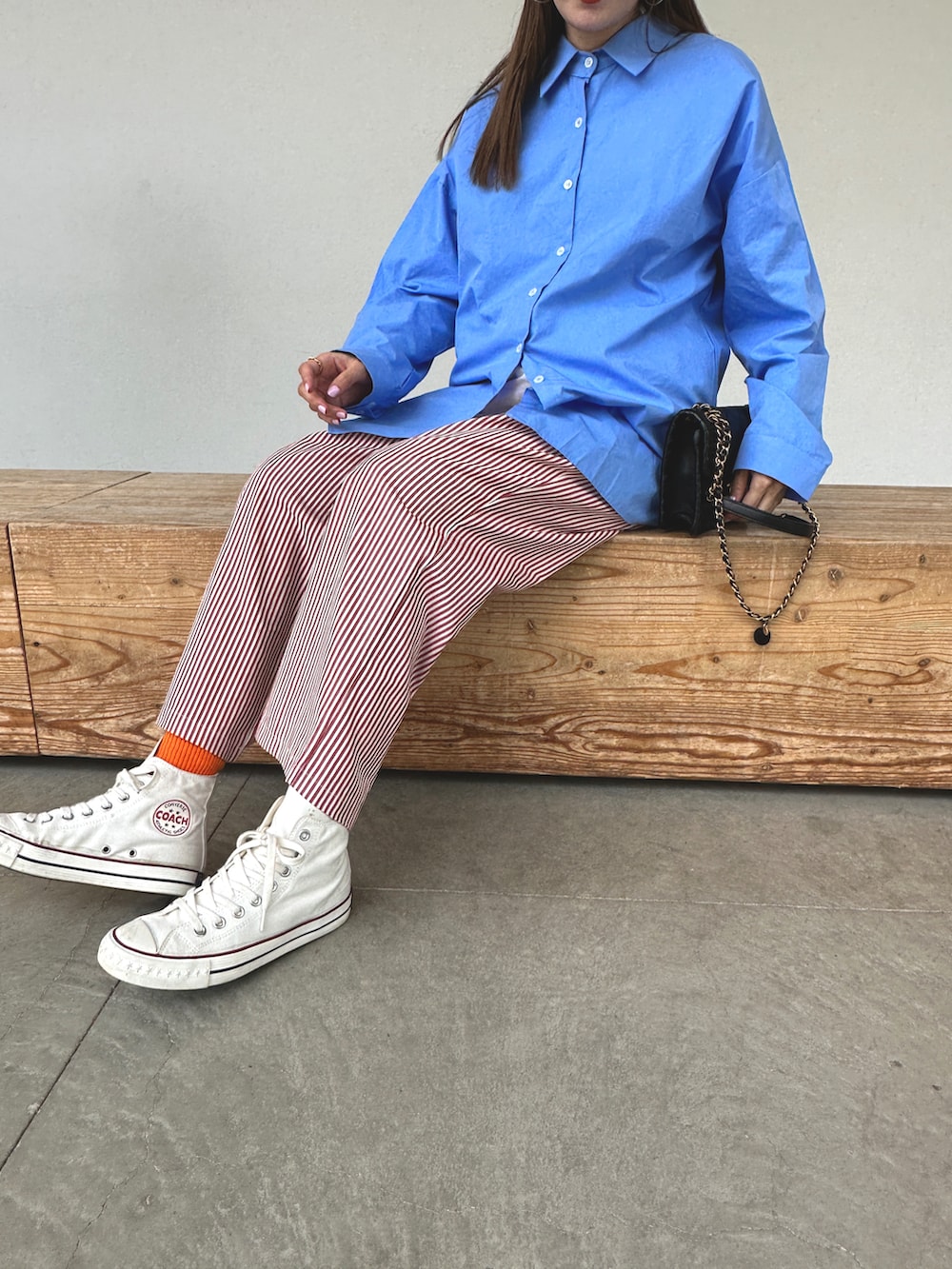 ブルー系のシャツ/ブラウス、レッド系のパンツ、ホワイト系のキャップを着用したレディースの春コーディネートの3枚目の写真