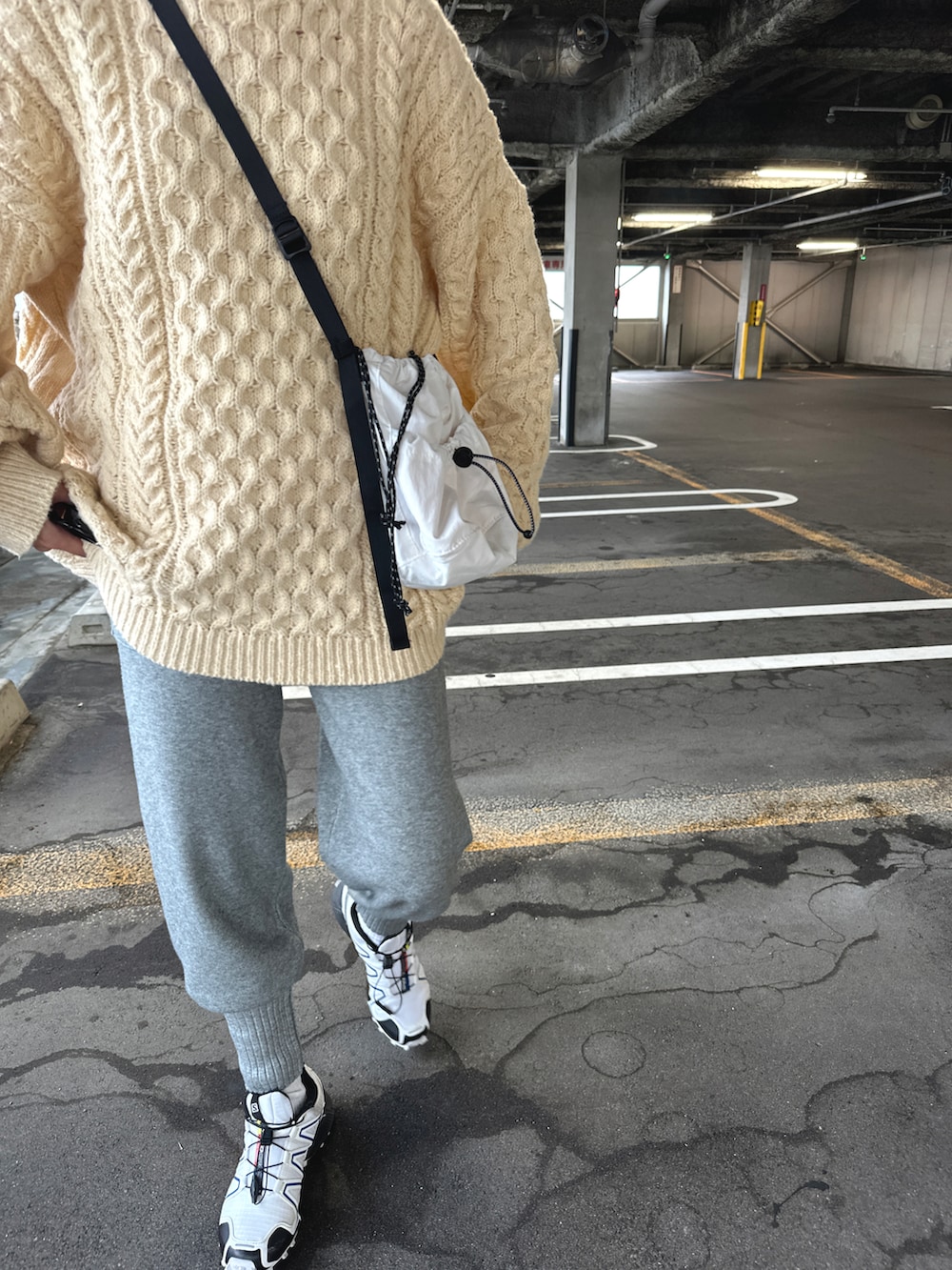 ホワイト系のスニーカー、グレー系のパンツ、ベージュ系のニット/セーターを着用したレディースの秋コーディネートの2枚目の写真