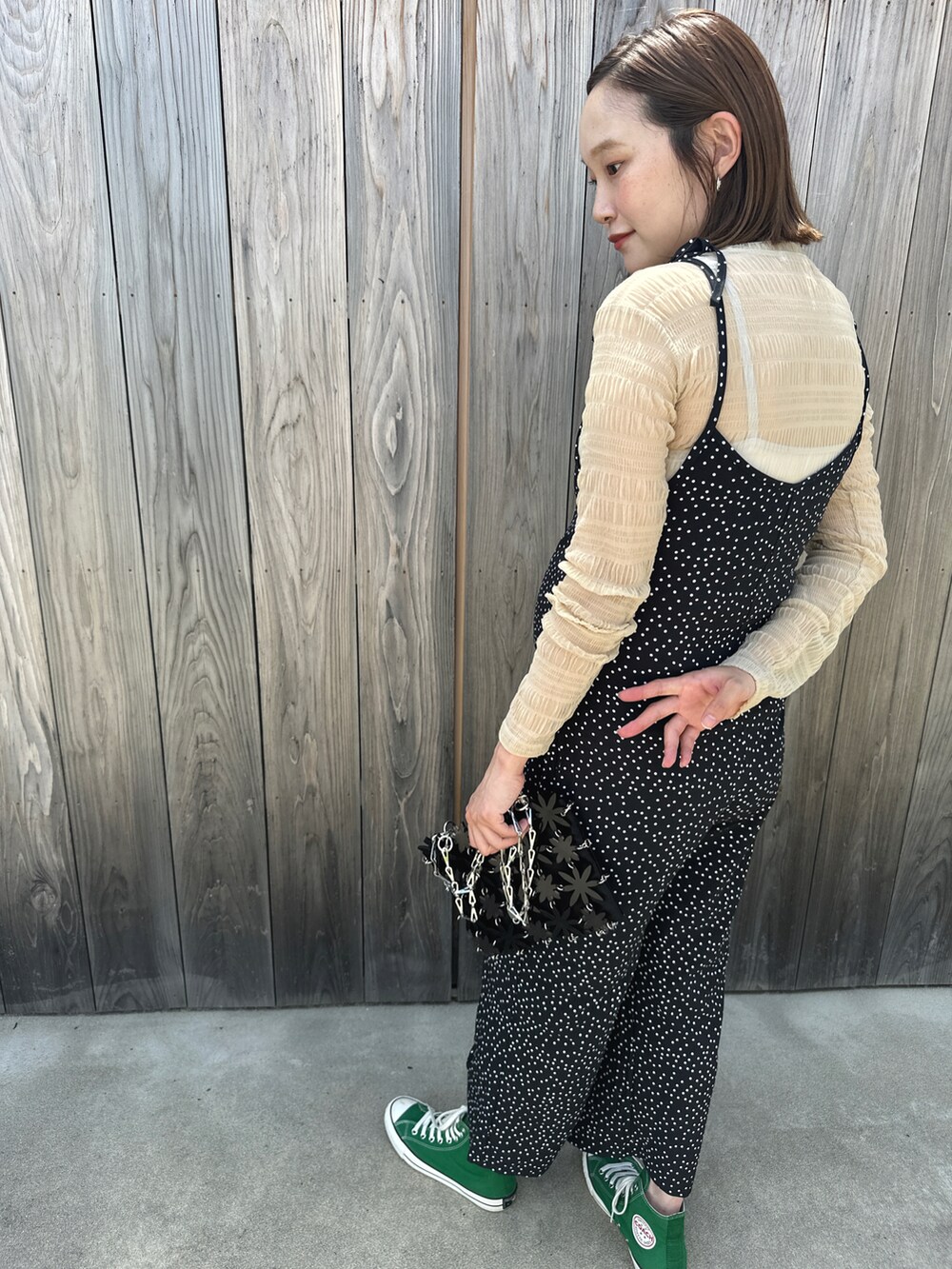 グリーン系のスニーカー、ブラック系のオールインワン・サロペット、ブラック系のショルダーバッグを着用したレディースの夏コーディネートの2枚目の写真