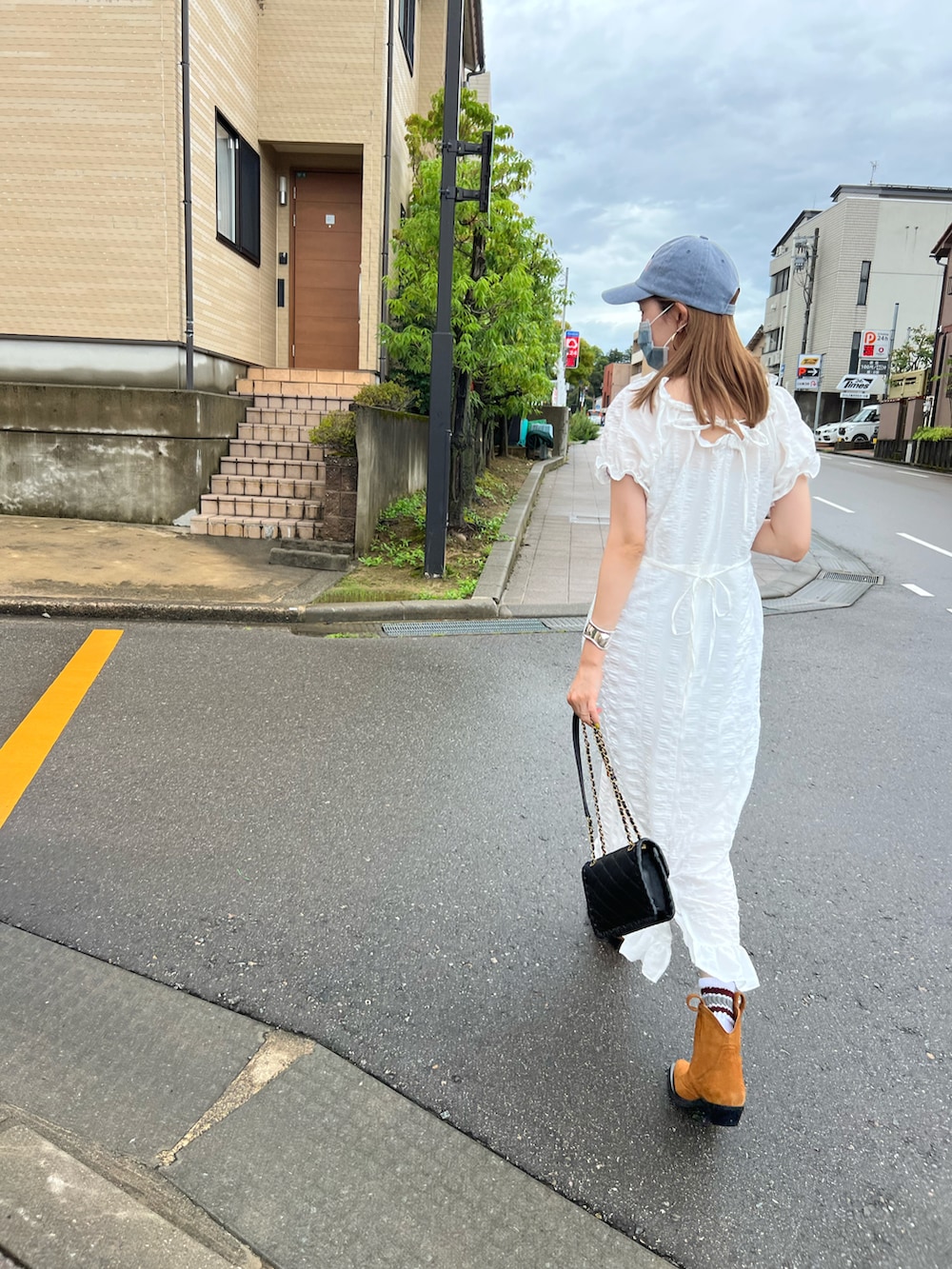 ホワイト系のワンピース/ドレス、ブラウン系のブーツ、ブルー系のキャップを着用したレディースの夏コーディネートの2枚目の写真