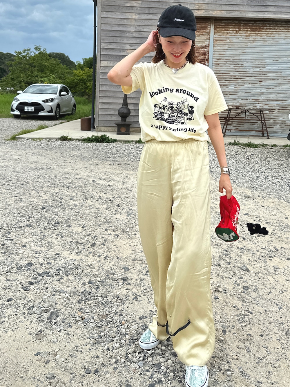 イエロー系のTシャツ/カットソー、ベージュ系のパンツ、グリーン系のシューズを着用したレディースの夏コーディネートの3枚目の写真