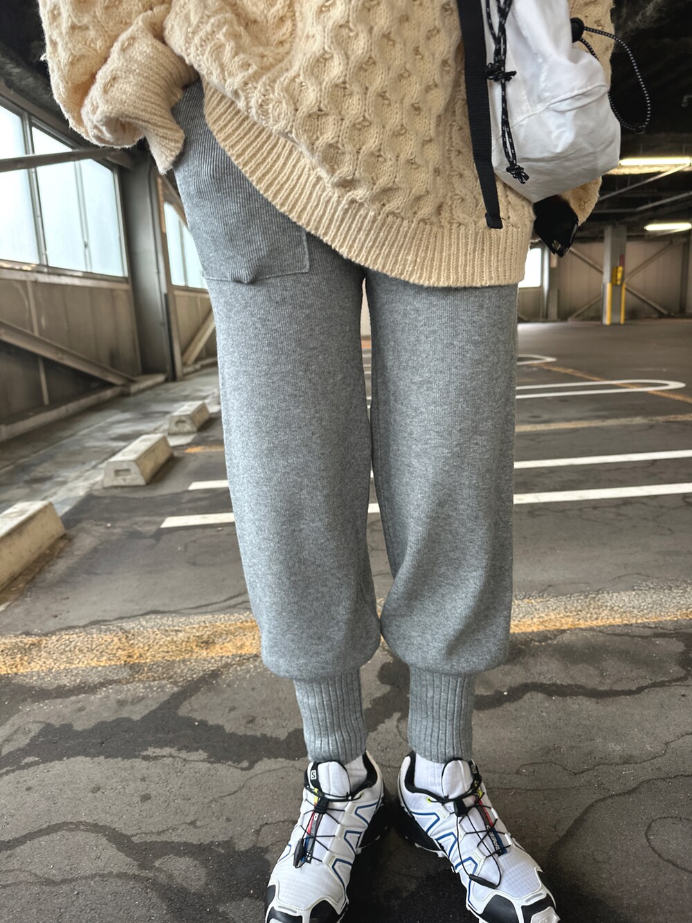 ホワイト系のスニーカー、グレー系のパンツ、ベージュ系のニット/セーターを着用したレディースの秋コーディネートの3枚目の写真