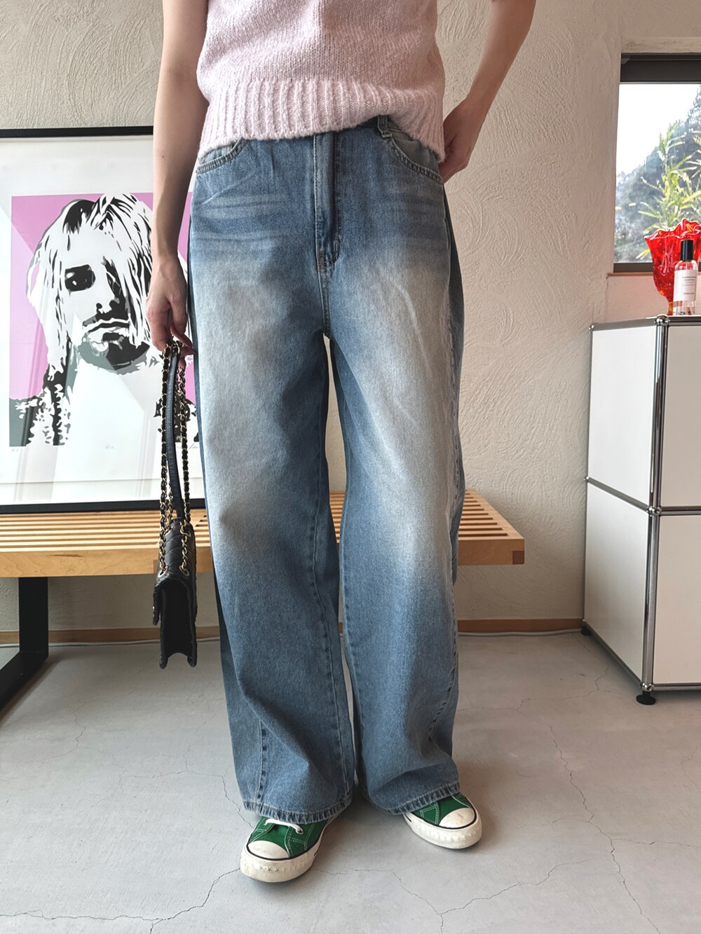 ブルー系のデニムパンツ、ピンク系のニット/セーター、グリーン系のスニーカーを着用したレディースの春コーディネートの3枚目の写真