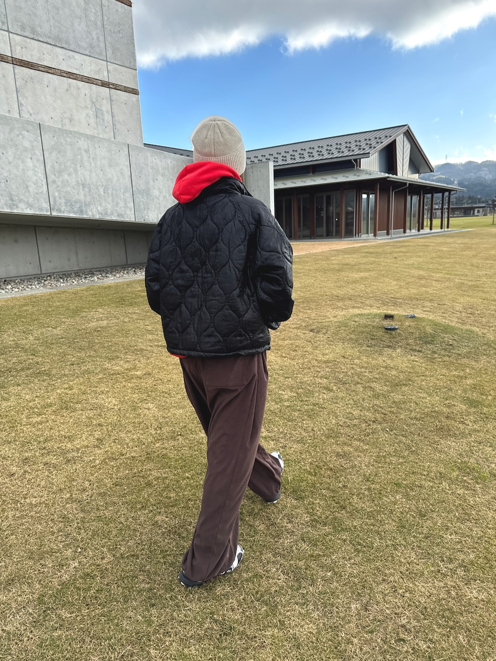 ブラウン系のパンツ、ブラック系のジャケット/アウター、ブラウン系のメガネを着用したレディースの冬コーディネートの2枚目の写真