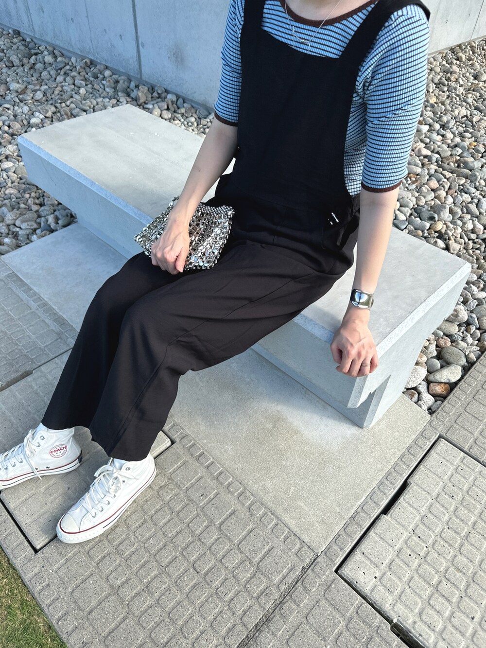 ブラック系のオールインワン・サロペット、ブルー系のトップス、シルバー系のバッグを着用したレディースの秋コーディネートの4枚目の写真