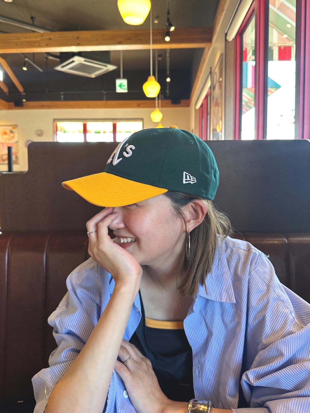 ブルー系のワンピース/ドレス、ブラウン系のスニーカー、グリーン系のキャップを着用したレディースの夏コーディネートの3枚目の写真