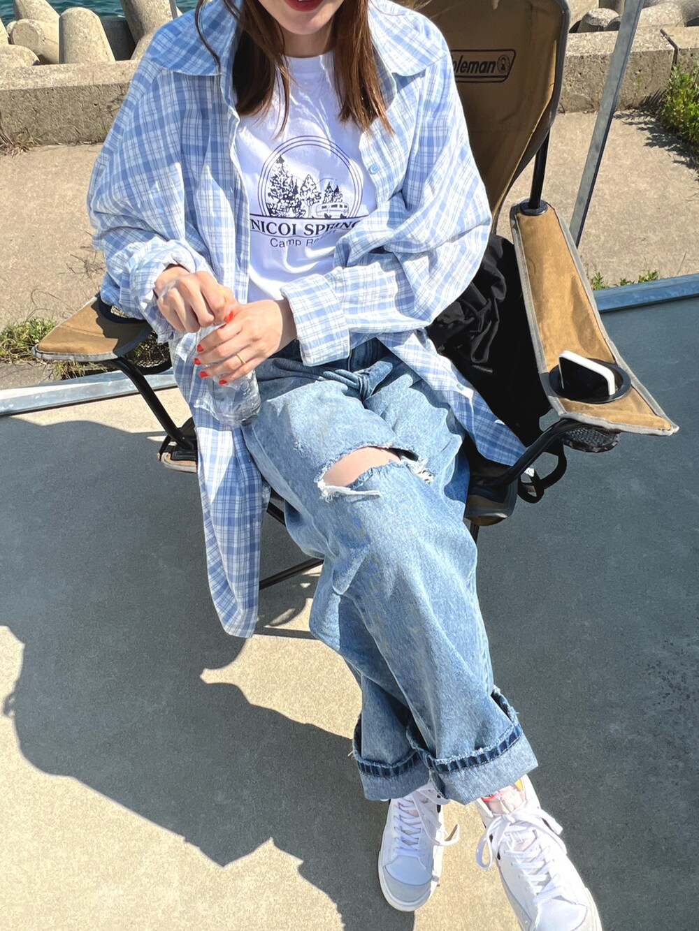 ブルー系のシャツ/ブラウス、ブルー系のデニムパンツ、ホワイト系のスニーカーを着用したレディースの春コーディネートの2枚目の写真