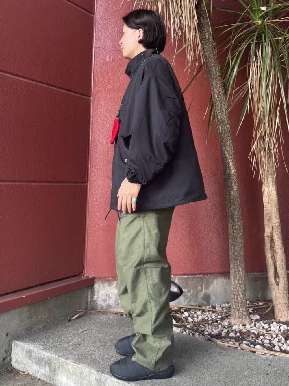 ブラック系のブルゾン、レッド系のコインケースを着用したメンズの秋コーディネートの2枚目の写真