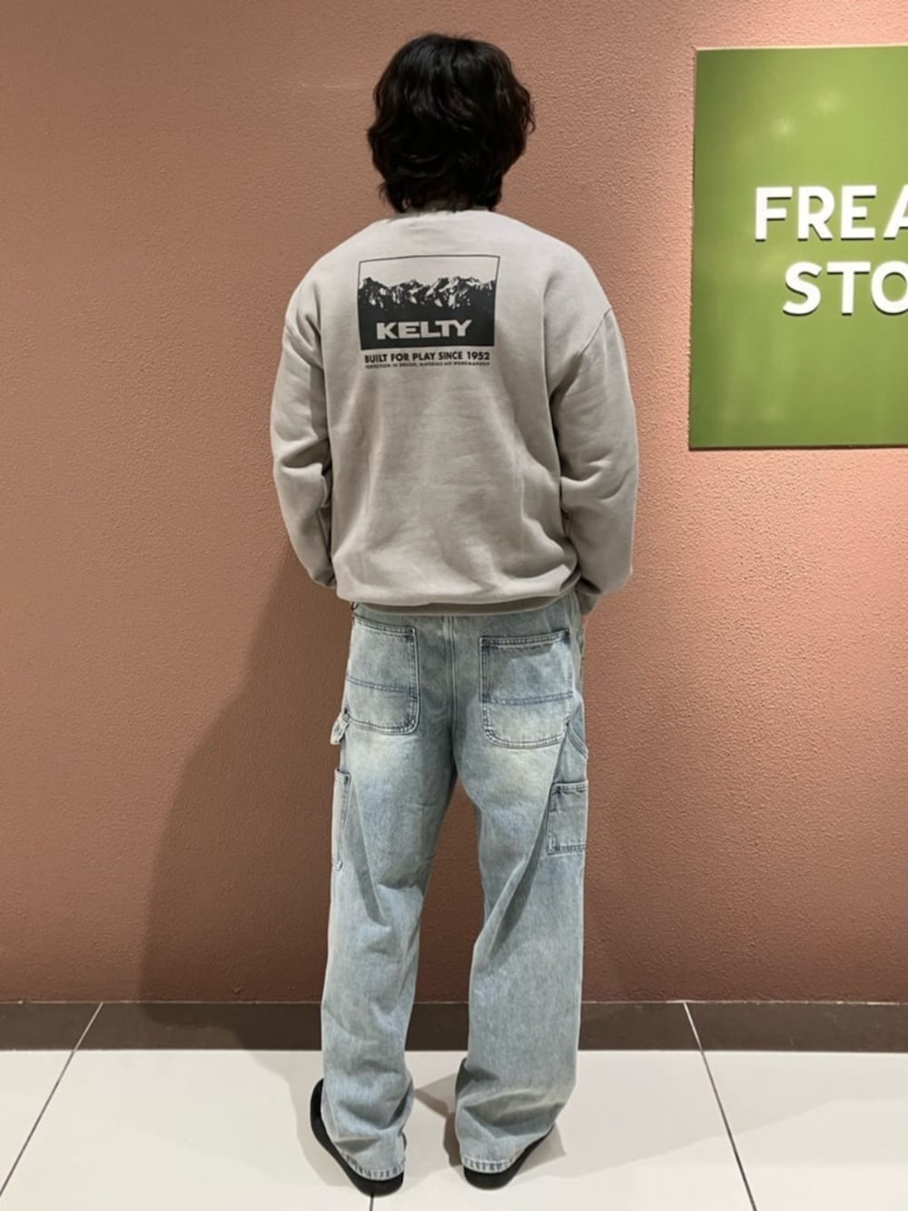 ブルー系のデニムパンツ、ベージュ系のスウェットを着用したメンズの秋コーディネートの2枚目の写真