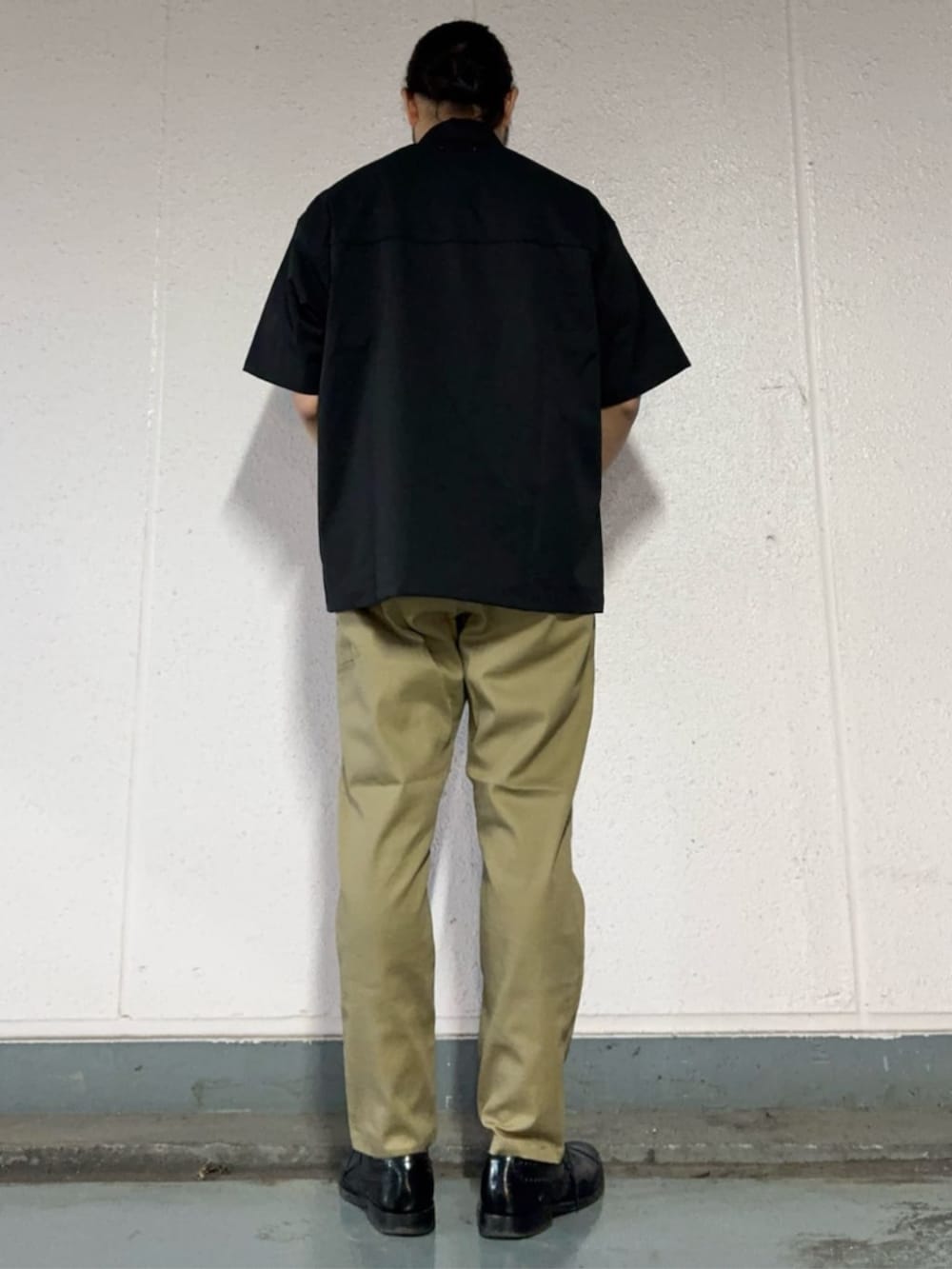 ベージュ系のチノパンツ、ブラック系のシャツ/ブラウスを着用したメンズの春コーディネートの3枚目の写真