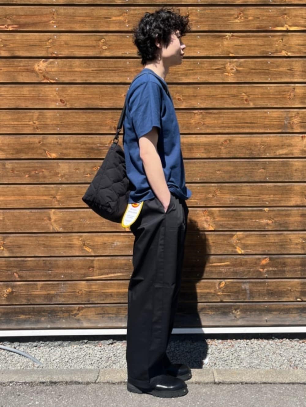 ブルー系のTシャツ/カットソー、ブラック系のチノパンツを着用したメンズの春コーディネートの2枚目の写真