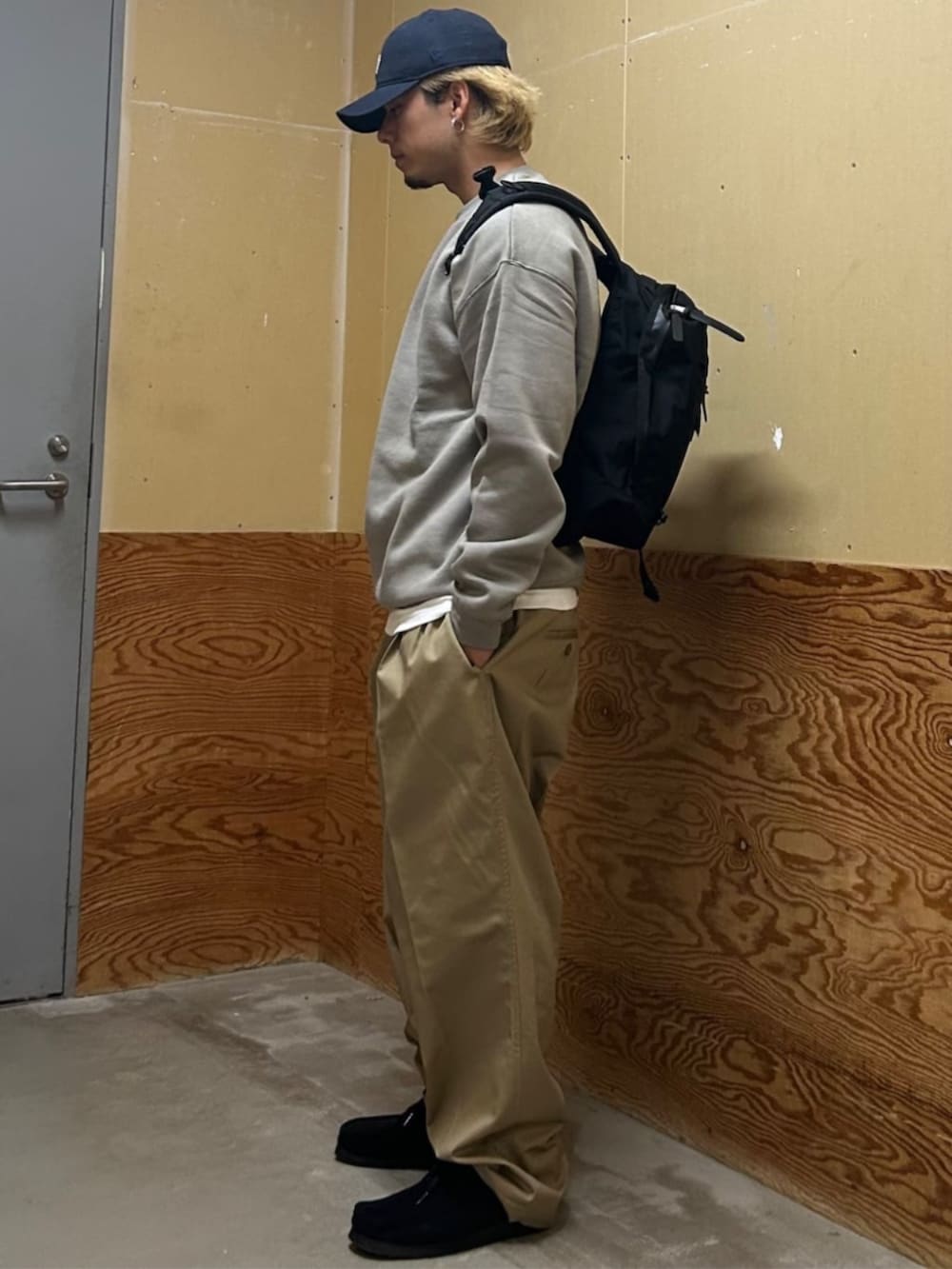 ベージュ系のスウェット、ベージュ系のチノパンツ、ブルー系のキャップを着用したメンズの秋コーディネートの2枚目の写真