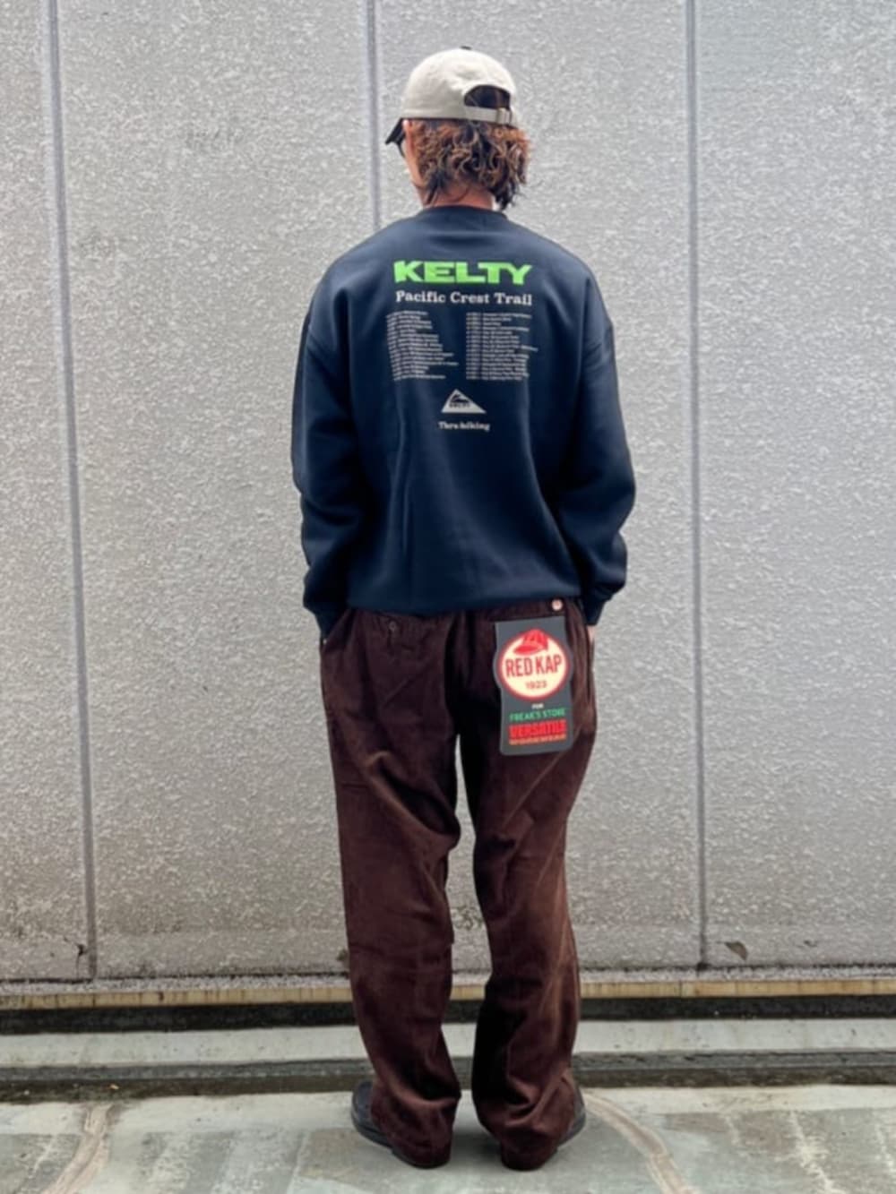 ブラック系のスウェット、ブラウン系のその他パンツ、ホワイト系のキャップを着用したメンズの秋コーディネートの3枚目の写真