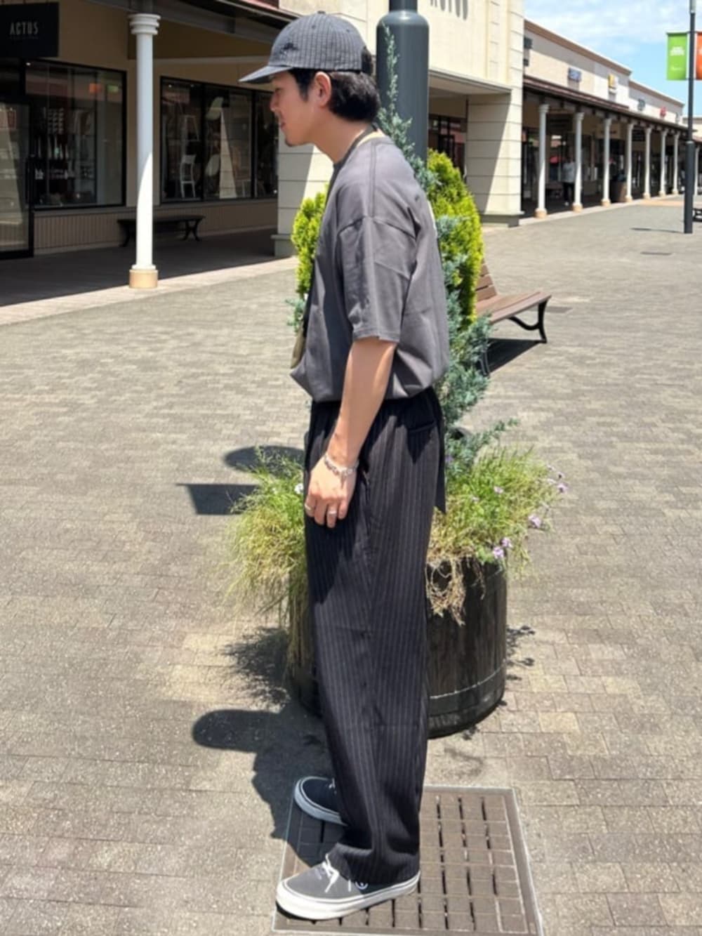 ブラック系のTシャツ/カットソー、ブラック系のスラックス、その他のキャップを着用したメンズの夏コーディネートの2枚目の写真