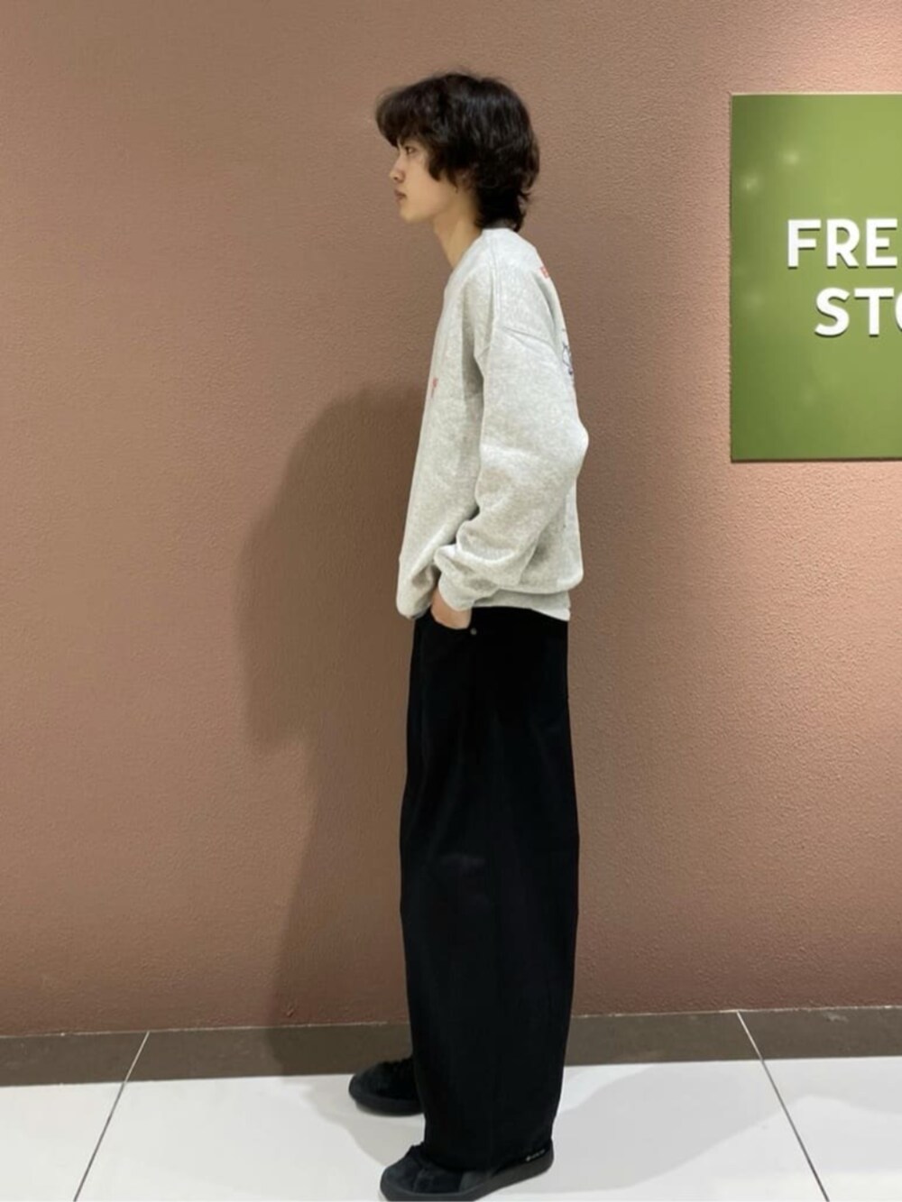 ブラック系のチノパンツ、グレー系のスウェットを着用したメンズの秋コーディネートの2枚目の写真