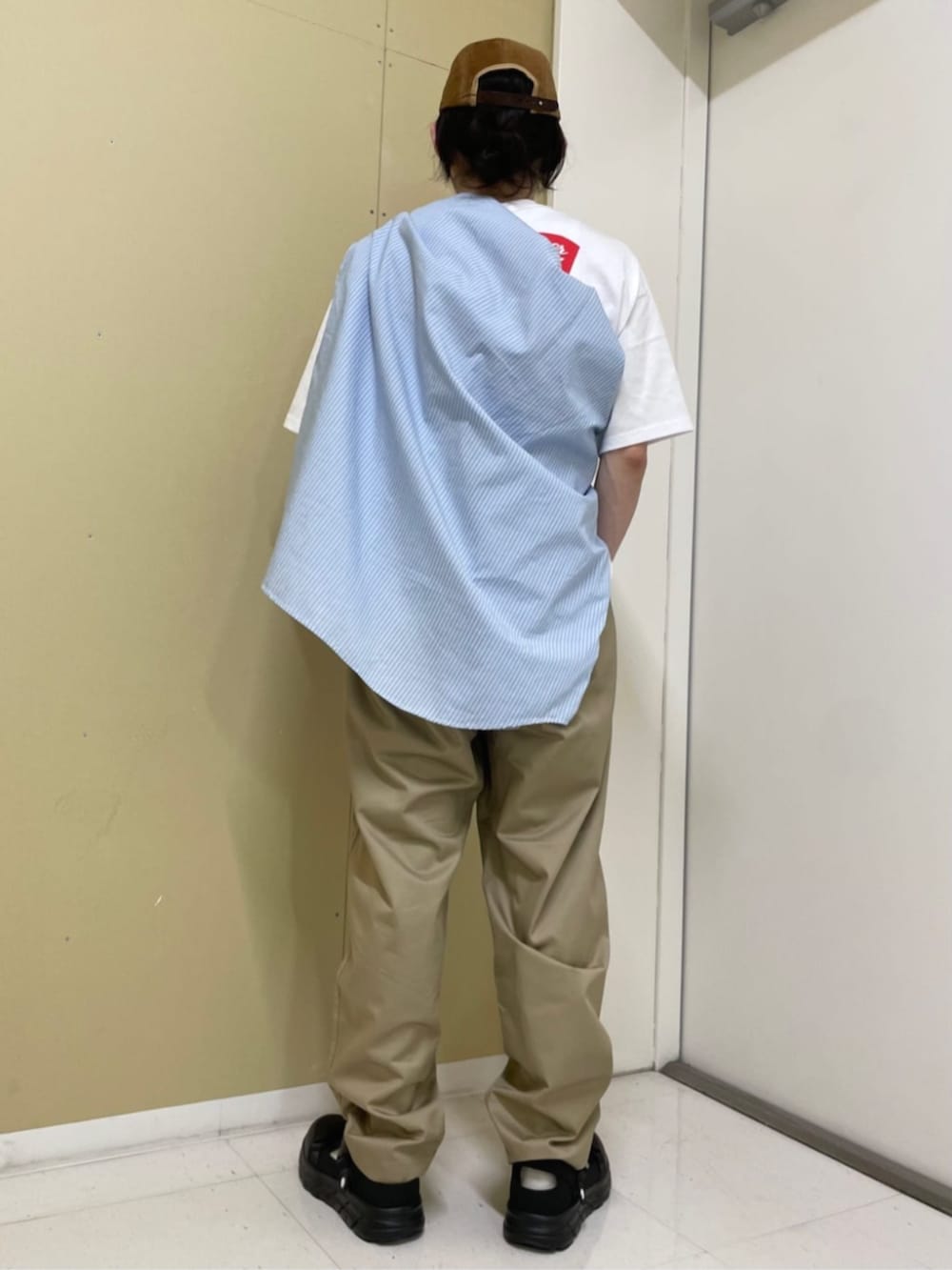 ホワイト系のTシャツ/カットソー、ベージュ系のチノパンツを着用したメンズの夏コーディネートの3枚目の写真