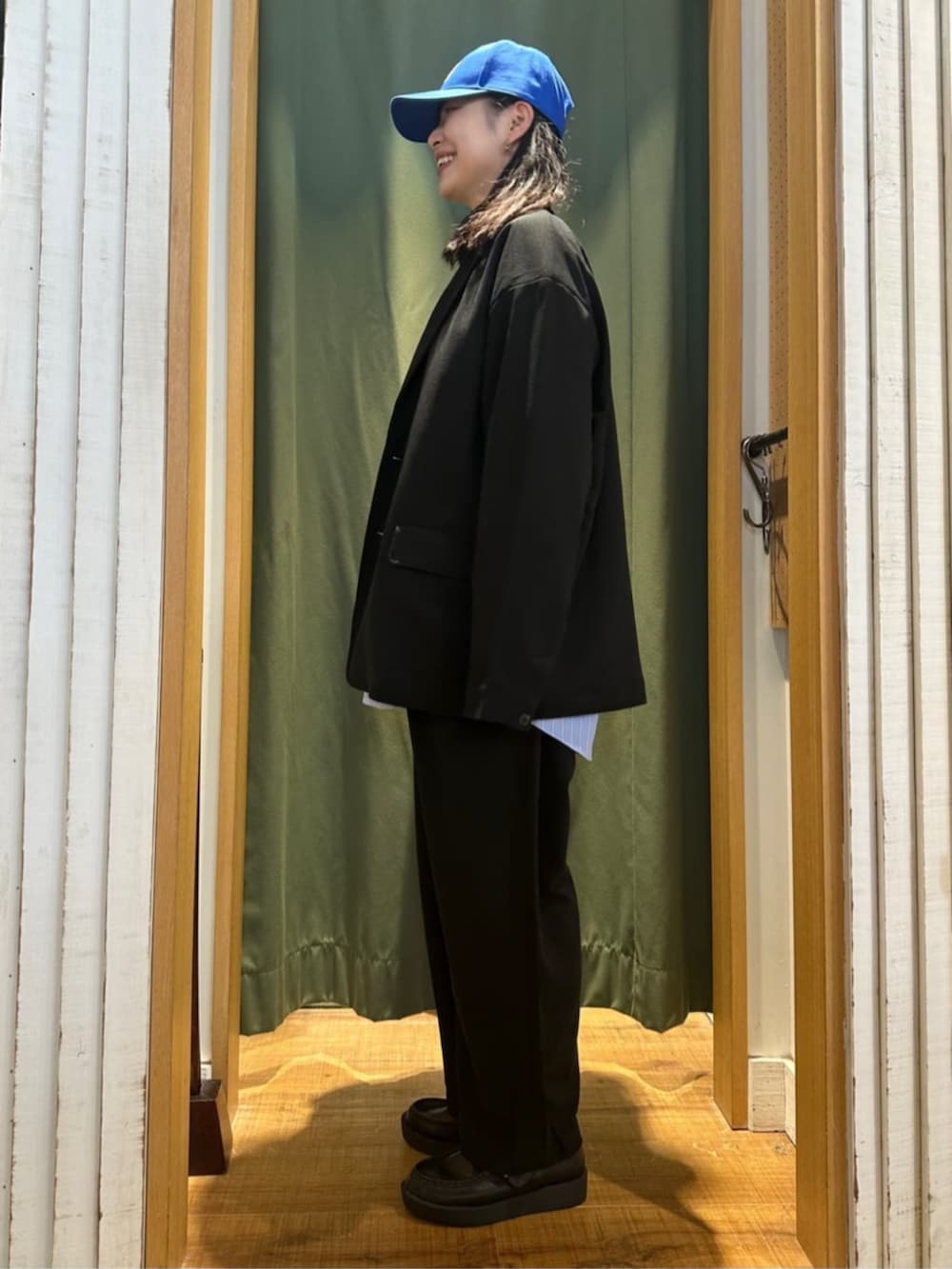 ブラック系のセットアップ、ブルー系のシャツ/ブラウス、ブルー系のキャップを着用したレディースの夏コーディネートの2枚目の写真