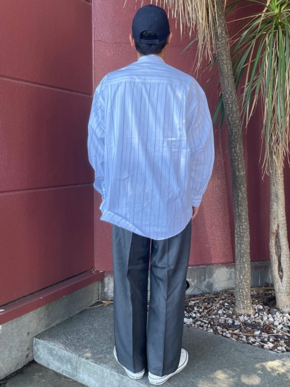 ホワイト系のシャツ/ブラウス、グレー系のスラックス、ブルー系のキャップを着用したメンズの夏コーディネートの3枚目の写真