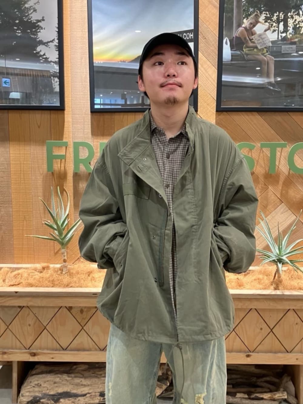 ブルー系のデニムパンツ、グリーン系のブルゾン、ブラウン系のシャツ/ブラウスを着用したメンズの秋コーディネートの4枚目の写真