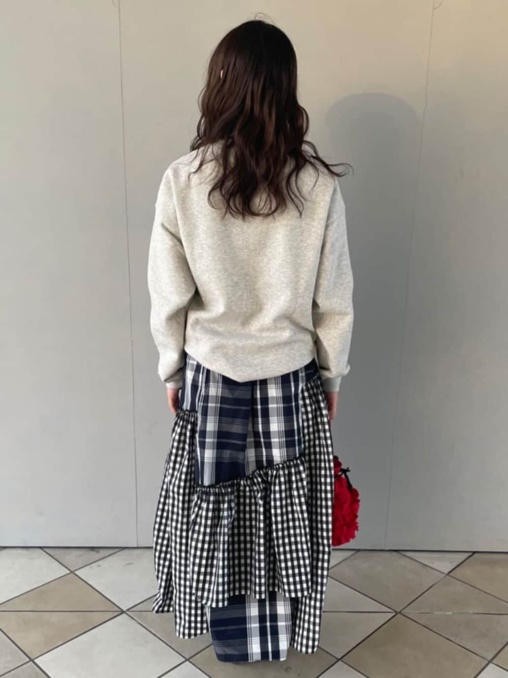 グレー系のスウェット、ブラック系のスカートを着用したレディースの秋コーディネートの3枚目の写真