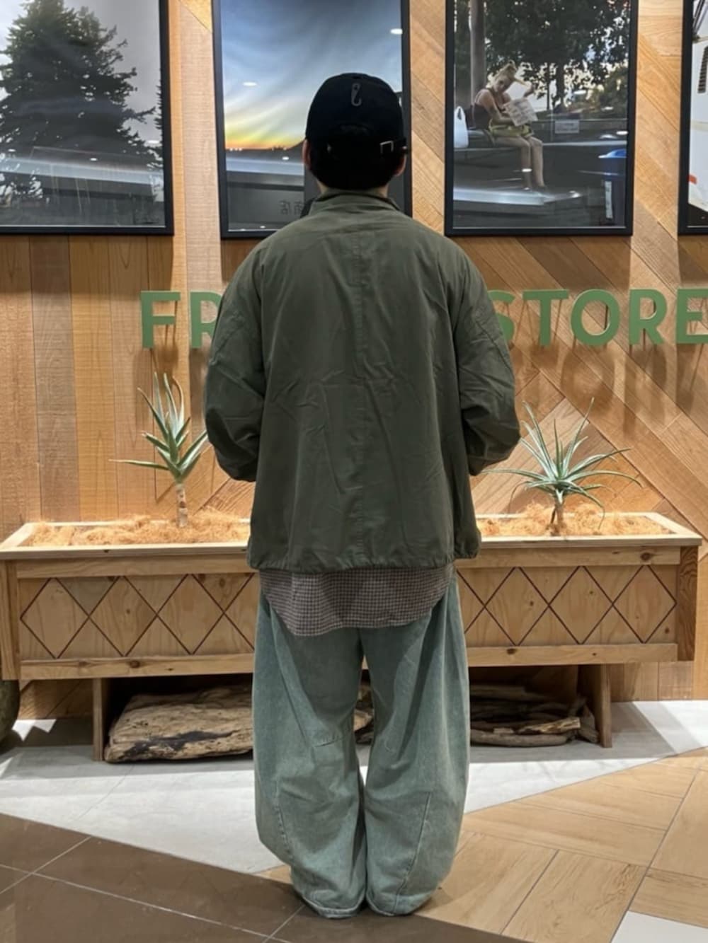 ブルー系のデニムパンツ、グリーン系のブルゾン、ブラウン系のシャツ/ブラウスを着用したメンズの秋コーディネートの3枚目の写真