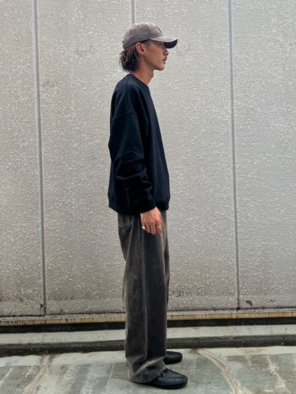 ブラック系のスウェット、ベージュ系のデニムパンツを着用したメンズの秋コーディネートの2枚目の写真