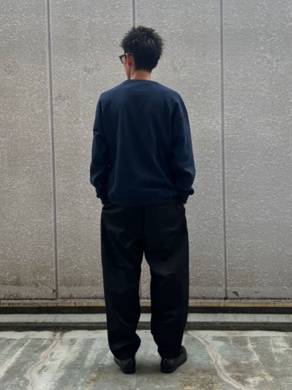 ブラック系のスウェット、ブラック系のチノパンツを着用したメンズの秋コーディネートの3枚目の写真