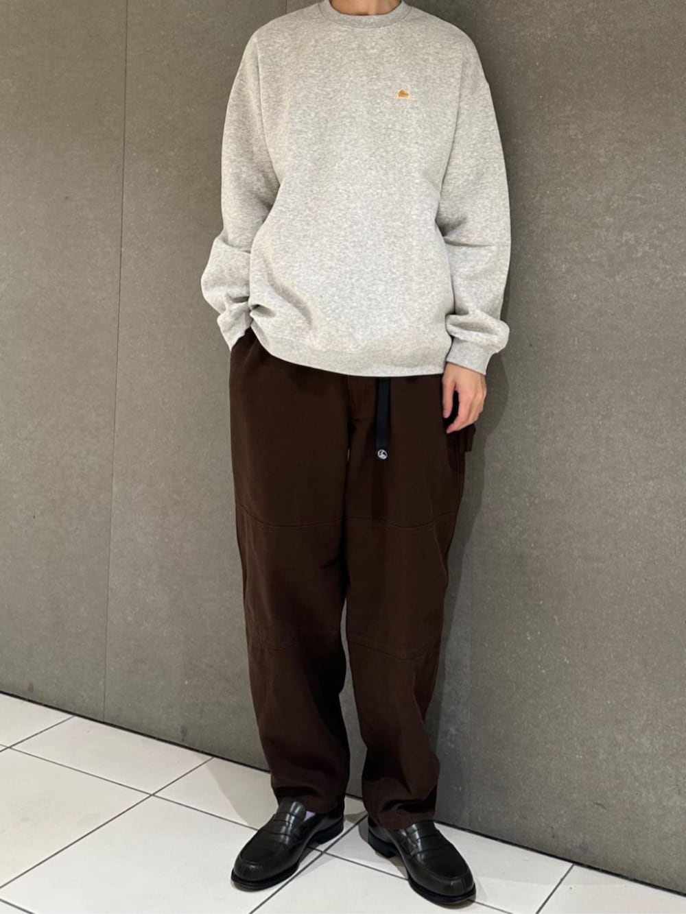 グレー系のスウェット、ブラウン系のその他パンツ、ホワイト系のキャップを着用したメンズの秋コーディネートの3枚目の写真