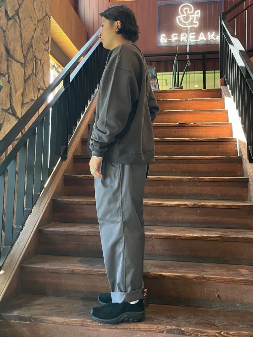 ブラック系のスウェット、ブラック系のショルダーバッグ、グレー系のチノパンツを着用したメンズの秋コーディネートの2枚目の写真