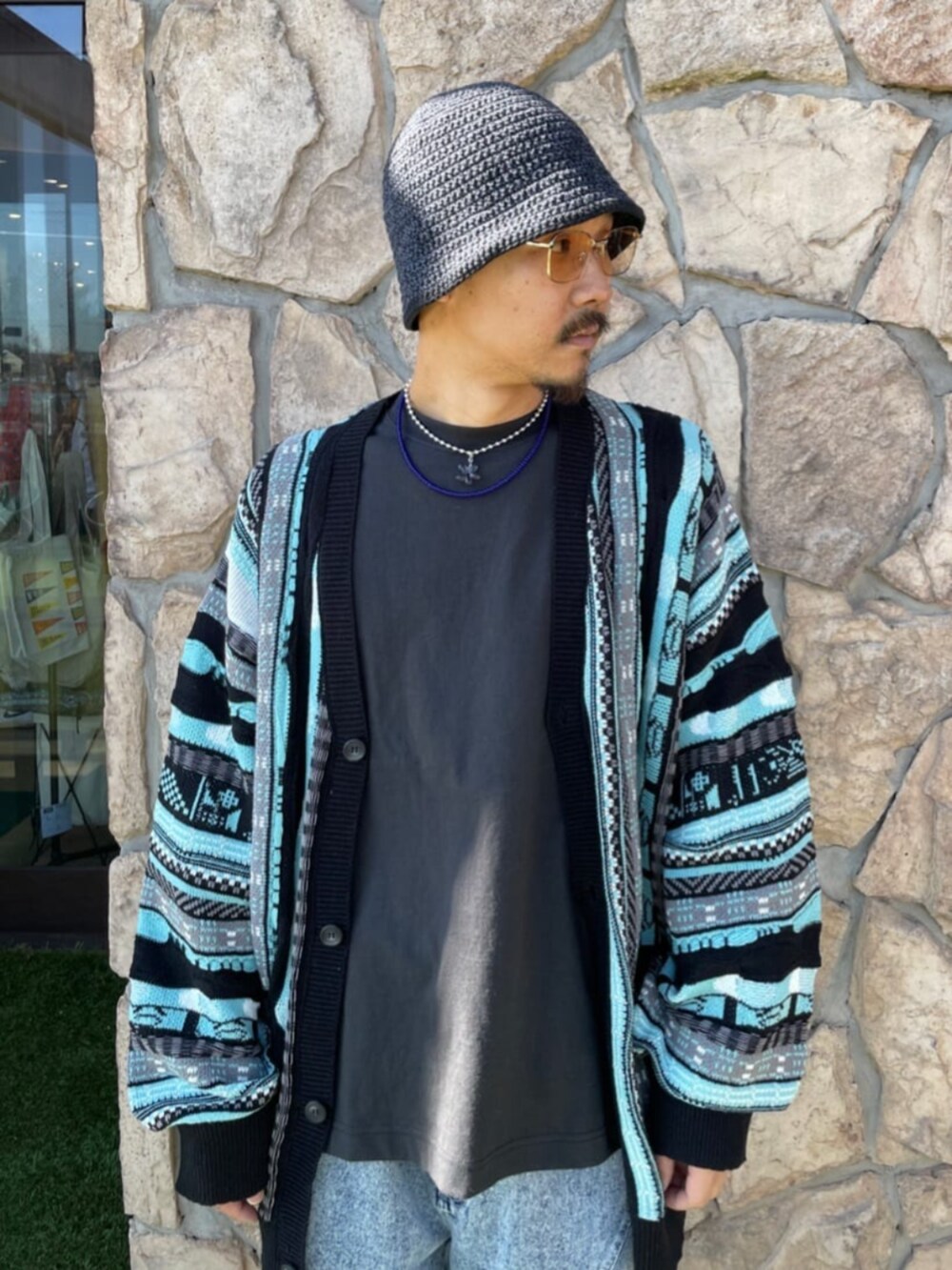 グレー系のTシャツ/カットソー、ブルー系のデニムパンツ、グリーン系のカーディガン/ボレロを着用したメンズの春コーディネートの2枚目の写真