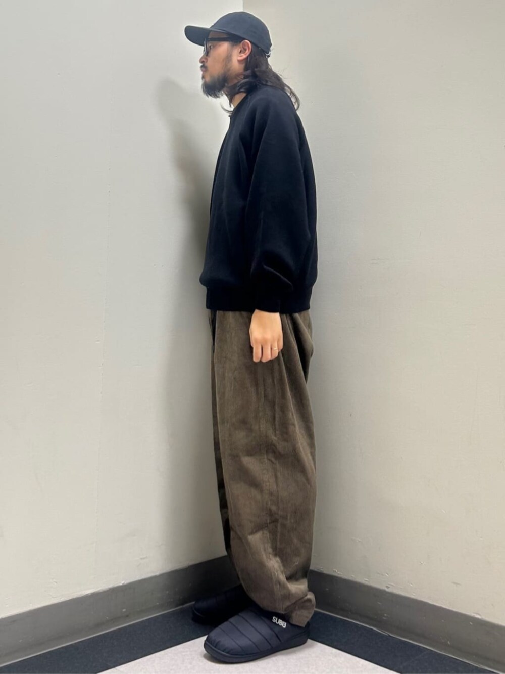 ブラック系のニット/セーター、ベージュ系のその他パンツを着用したメンズの秋コーディネートの2枚目の写真