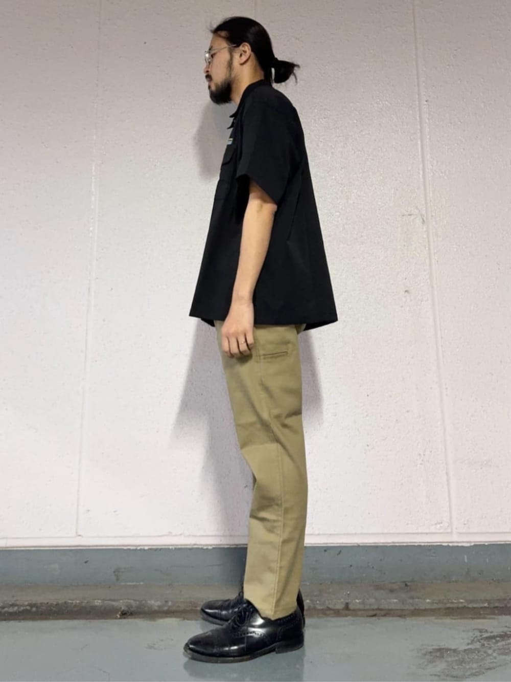 ベージュ系のチノパンツ、ブラック系のシャツ/ブラウスを着用したメンズの春コーディネートの2枚目の写真