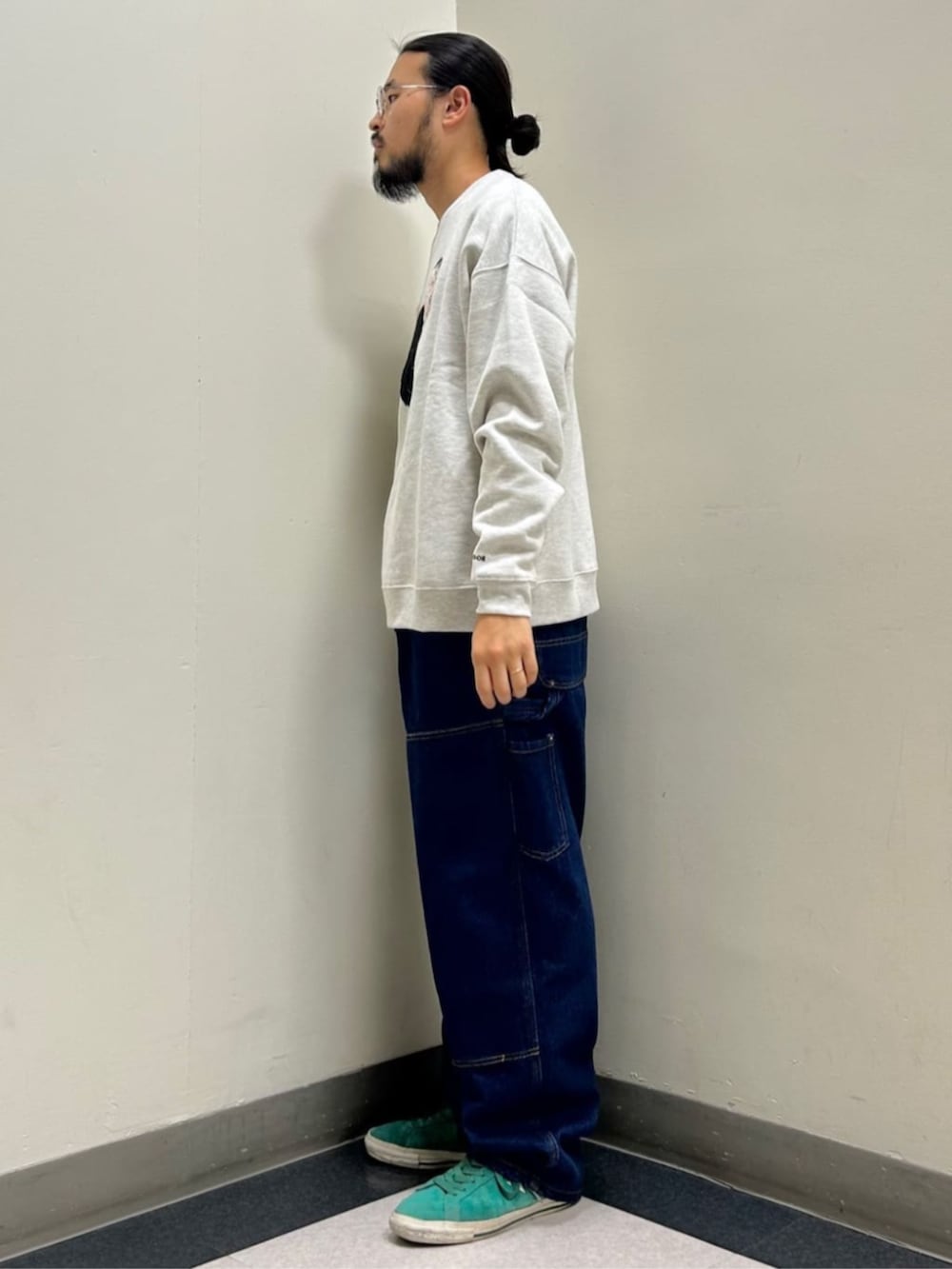 グレー系のスウェット、ブルー系のデニムパンツを着用したメンズの秋コーディネートの2枚目の写真