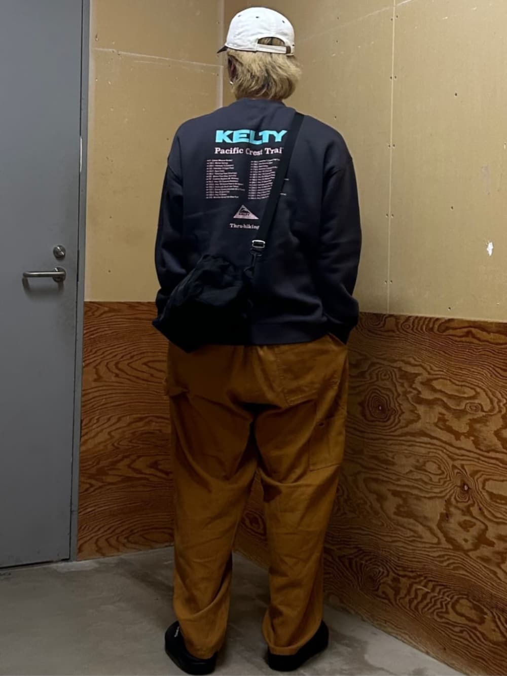 ブラック系のスウェット、ベージュ系のその他パンツ、ホワイト系のキャップを着用したメンズの秋コーディネートの3枚目の写真