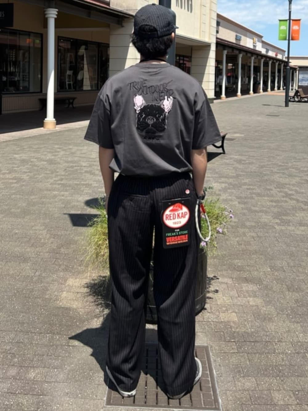 ブラック系のTシャツ/カットソー、ブラック系のスラックス、その他のキャップを着用したメンズの夏コーディネートの3枚目の写真