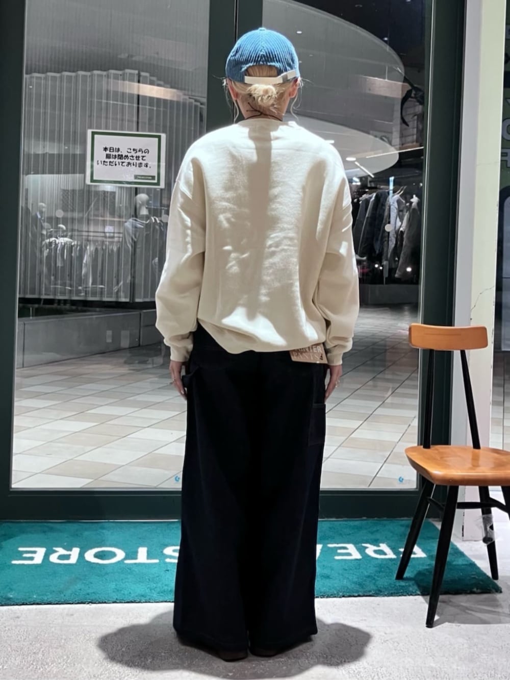 ホワイト系のスウェット、ブルー系のカーゴパンツ、ブルー系のキャップを着用したレディースの秋コーディネートの3枚目の写真