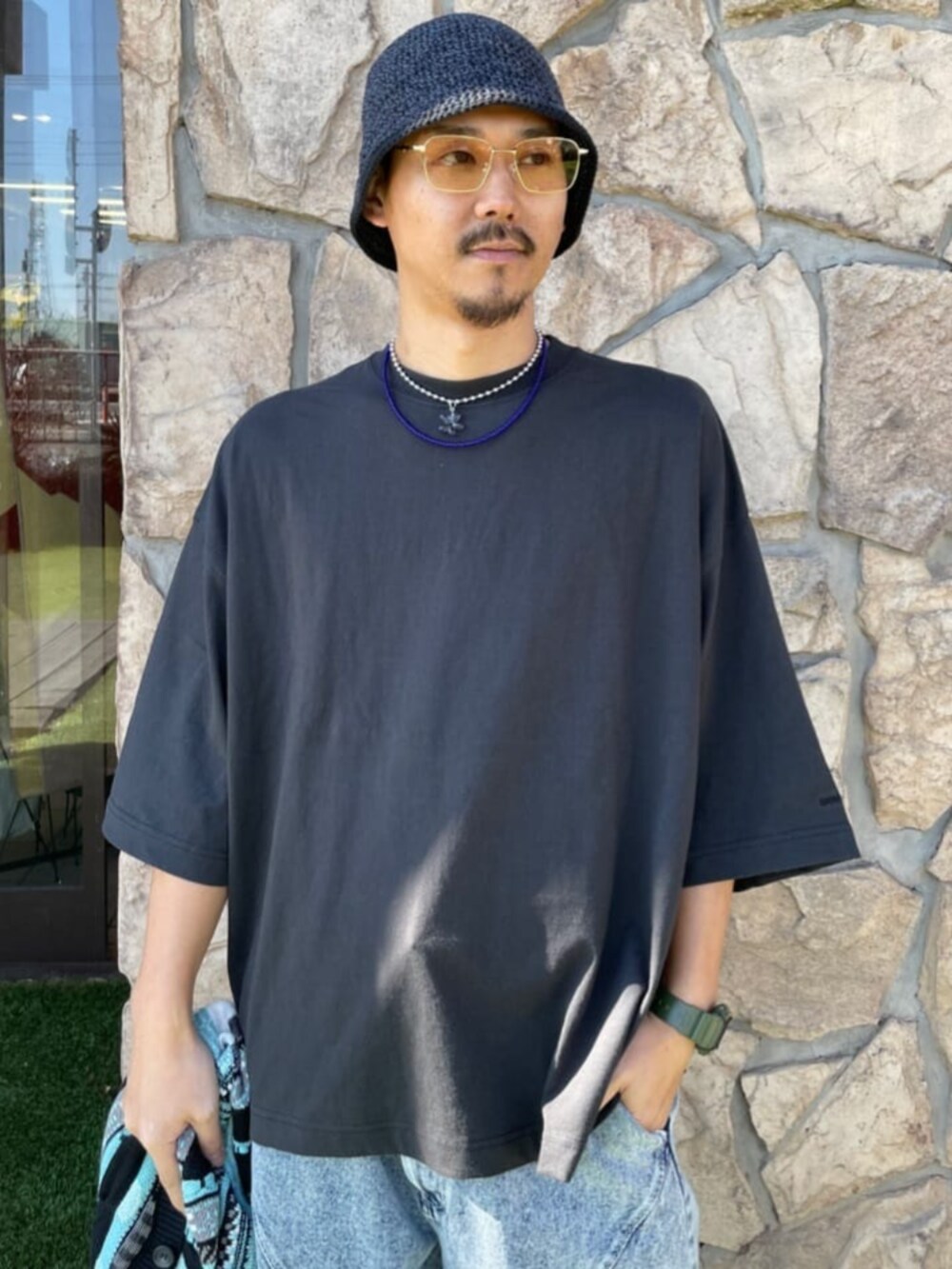 グレー系のTシャツ/カットソー、ブルー系のデニムパンツ、グリーン系のカーディガン/ボレロを着用したメンズの春コーディネートの3枚目の写真