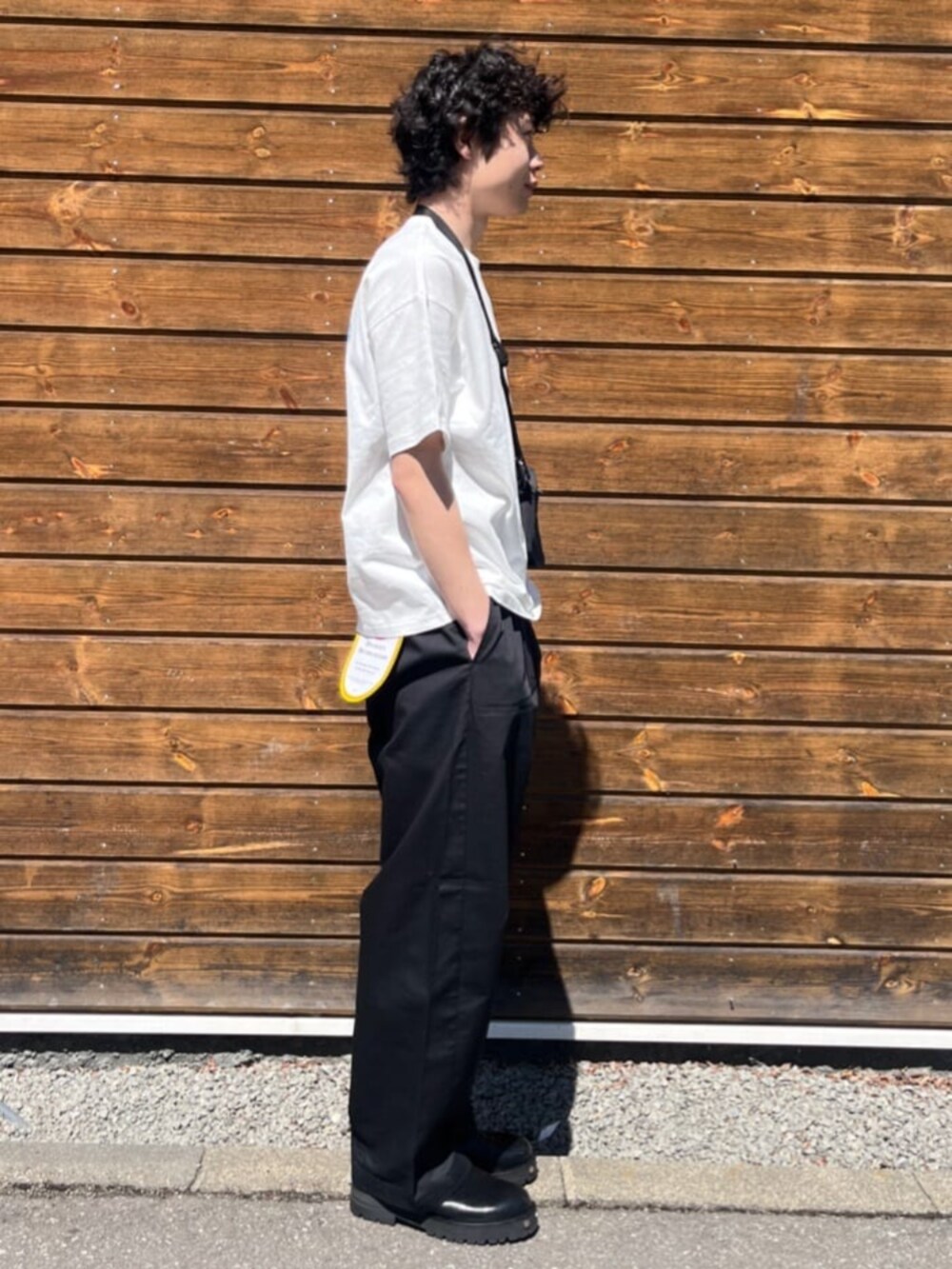 ブラック系のチノパンツ、ホワイト系のTシャツ/カットソーを着用したメンズの夏コーディネートの2枚目の写真