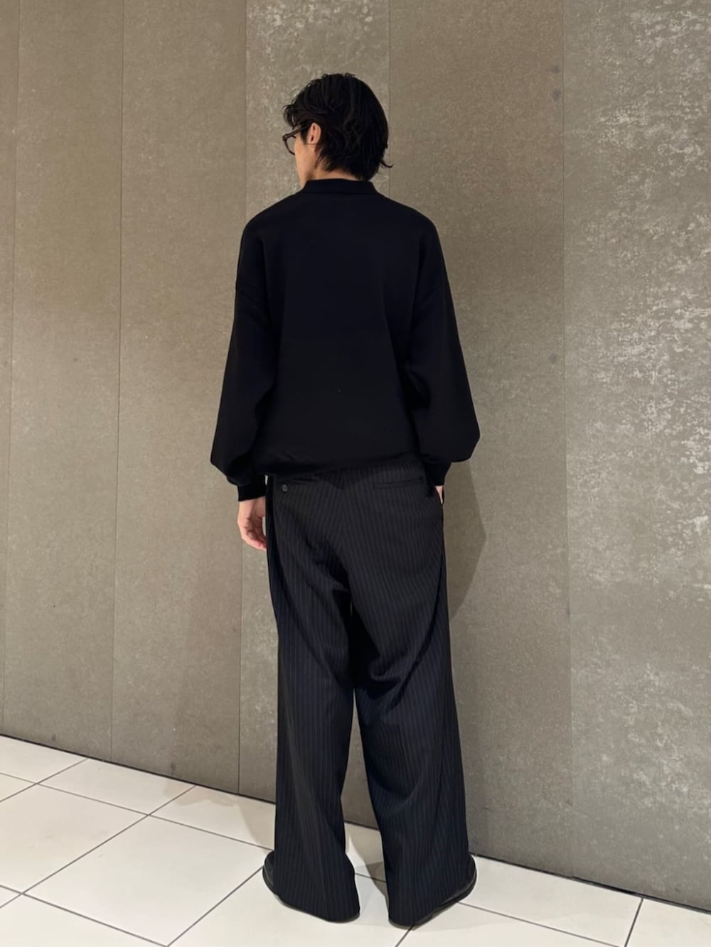 ブラック系のニット/セーター、ブラック系のスラックスを着用したメンズの秋コーディネートの4枚目の写真