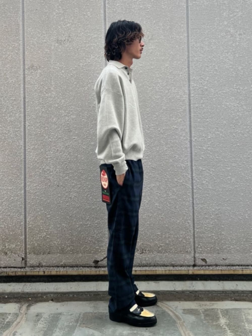 グレー系のニット/セーター、ブルー系のその他パンツを着用したメンズの秋コーディネートの2枚目の写真