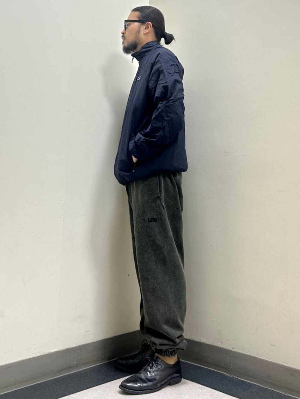 ブルー系のブルゾン、ブラック系のスウェットパンツを着用したメンズの秋コーディネートの2枚目の写真