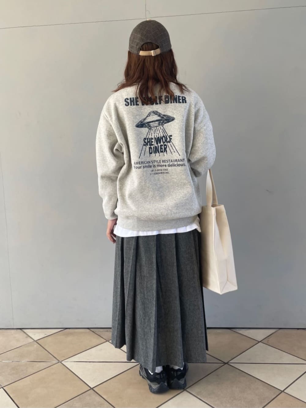 グレー系のスカート、グレー系のスウェット、ホワイト系のTシャツ/カットソーを着用したレディースの秋コーディネートの3枚目の写真