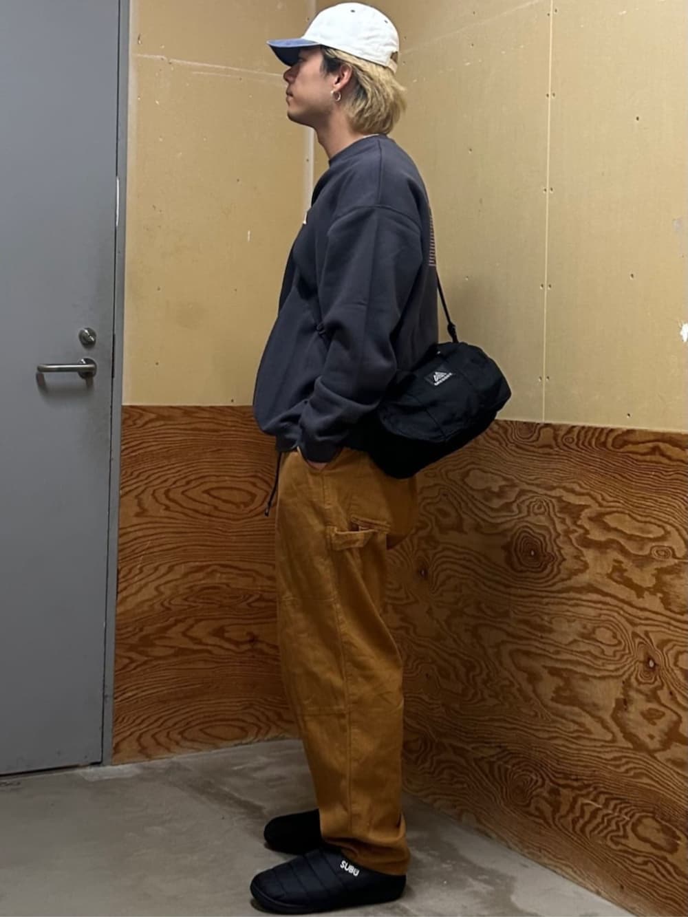 ブラック系のスウェット、ベージュ系のその他パンツ、ホワイト系のキャップを着用したメンズの秋コーディネートの2枚目の写真